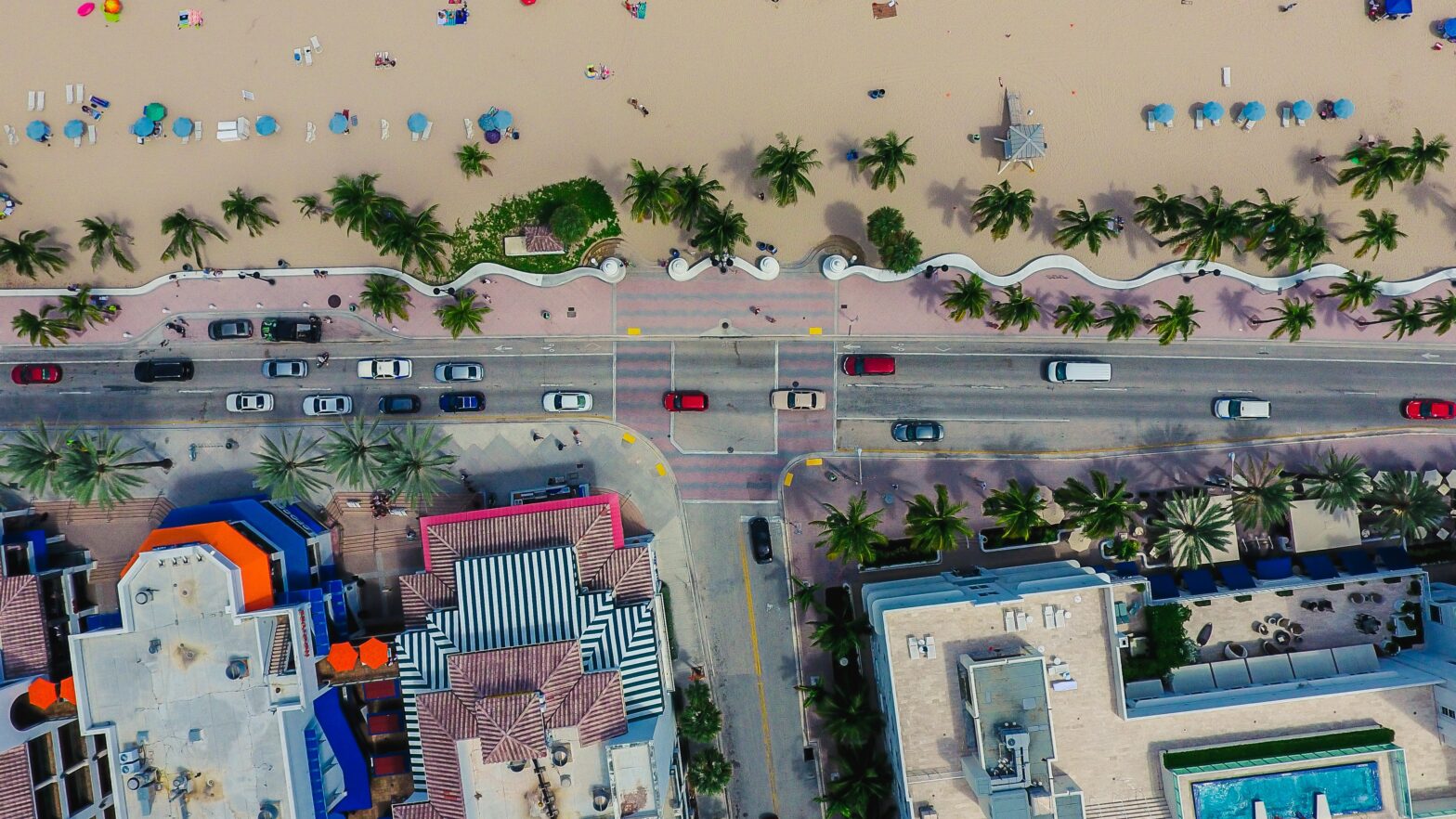 drone shot of South Florida Beach with colorful rooftops and cars driving down the strip in Miami