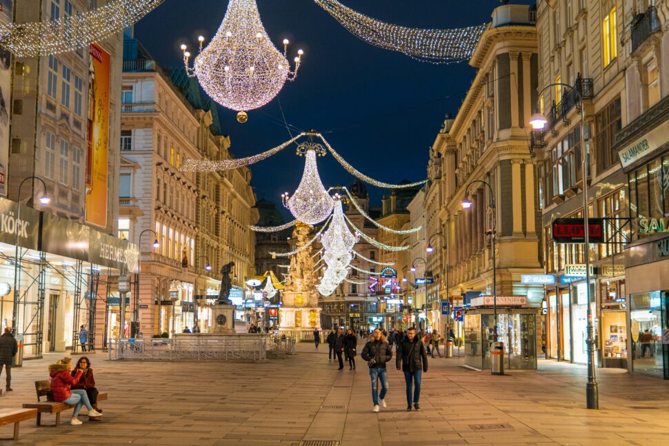 People walking under Christmas street decorations and lights in Vienna, Austria.