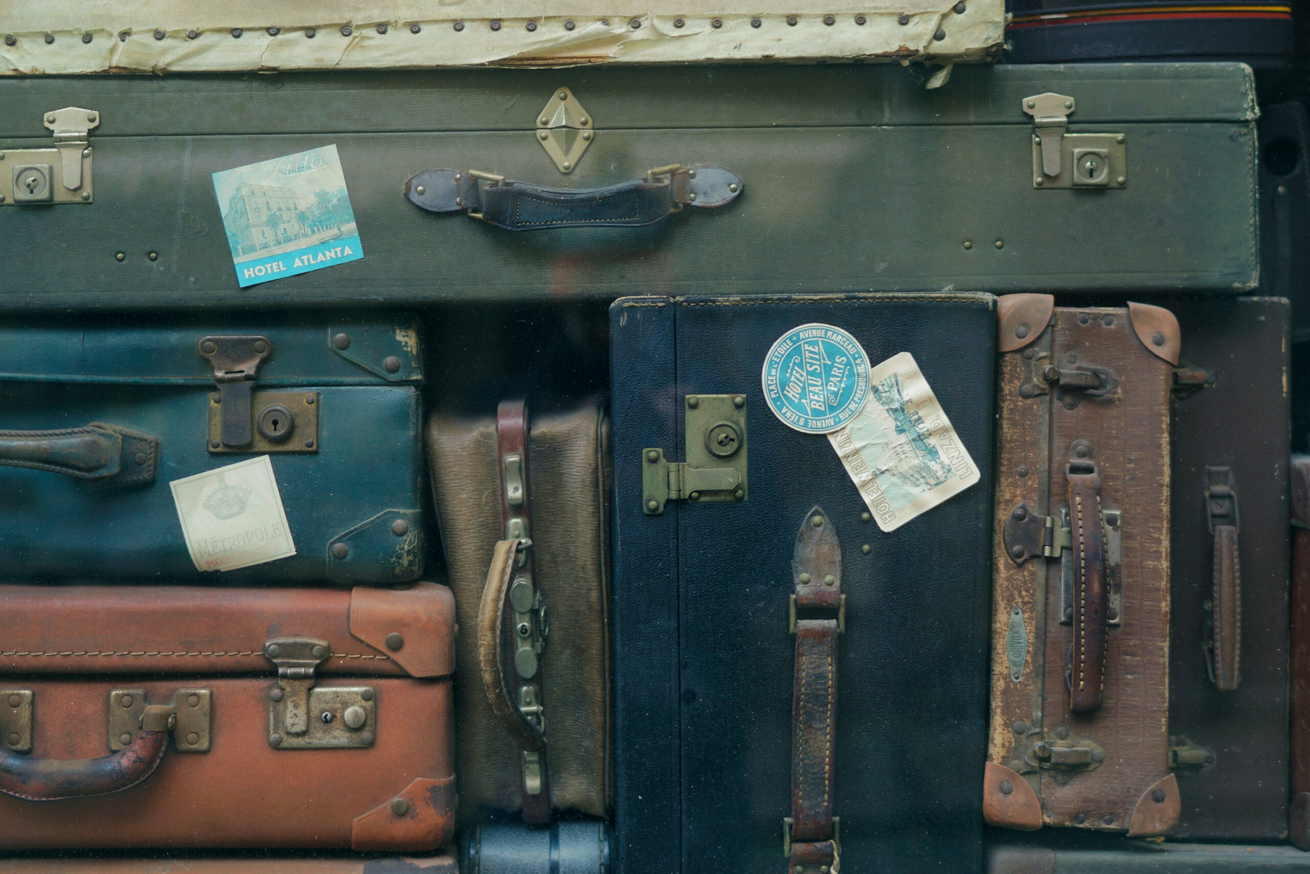 BudgetAir is a travel company that retrieves the best and cheapest flights available. Learn ways to use the platform to your advantage. 
pictured: a stack of suitcases with travel stickers on them from varying locations, like on a plane 