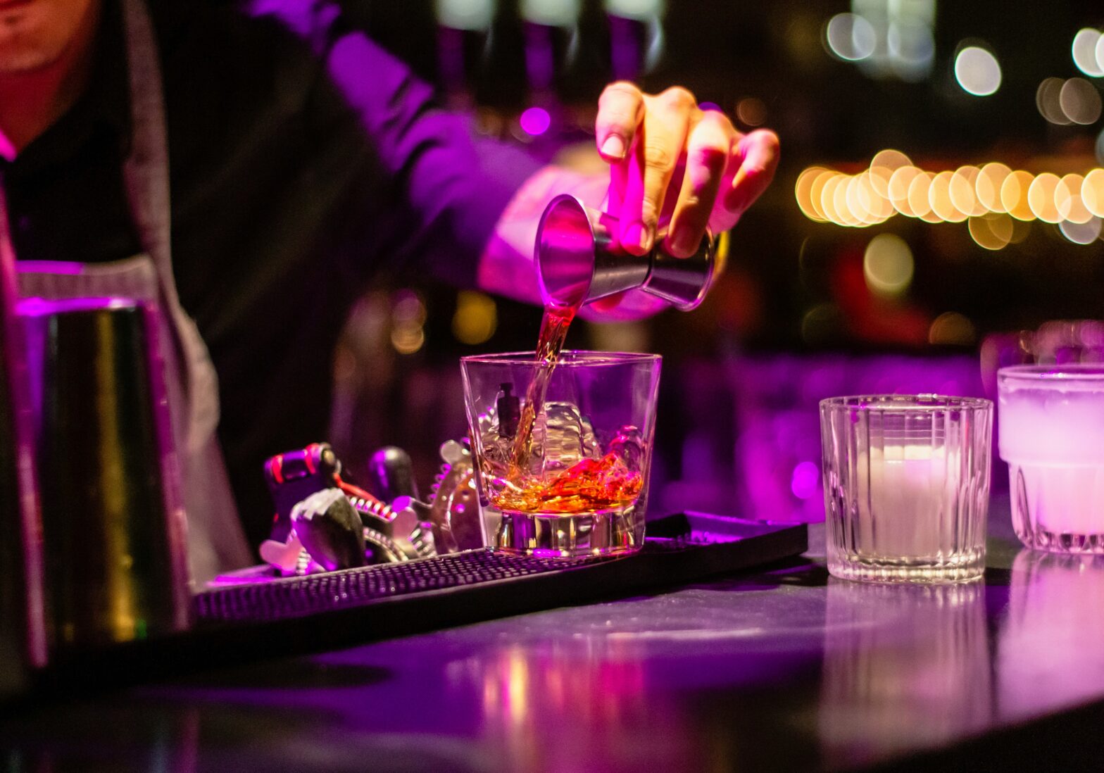 woman pouring cocktail at a speakeasy