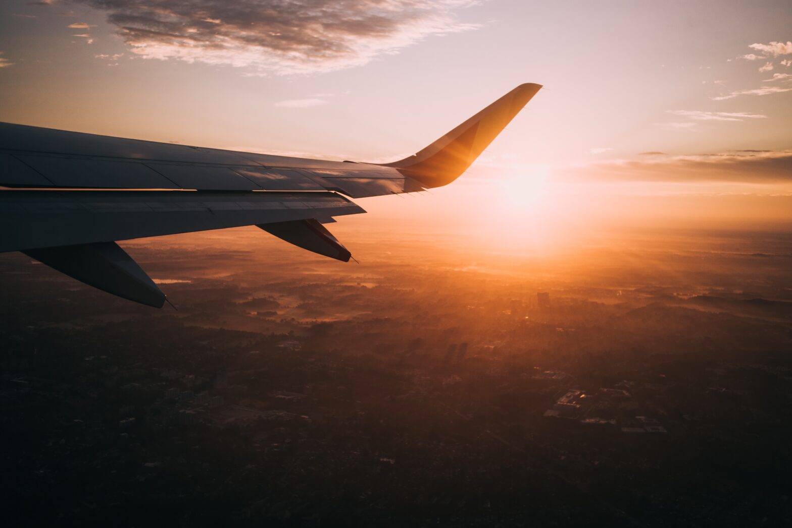 BudgetAir is an international travel agency that can be very useful for travelers. pictured: an airplane flying in the sky at sunset