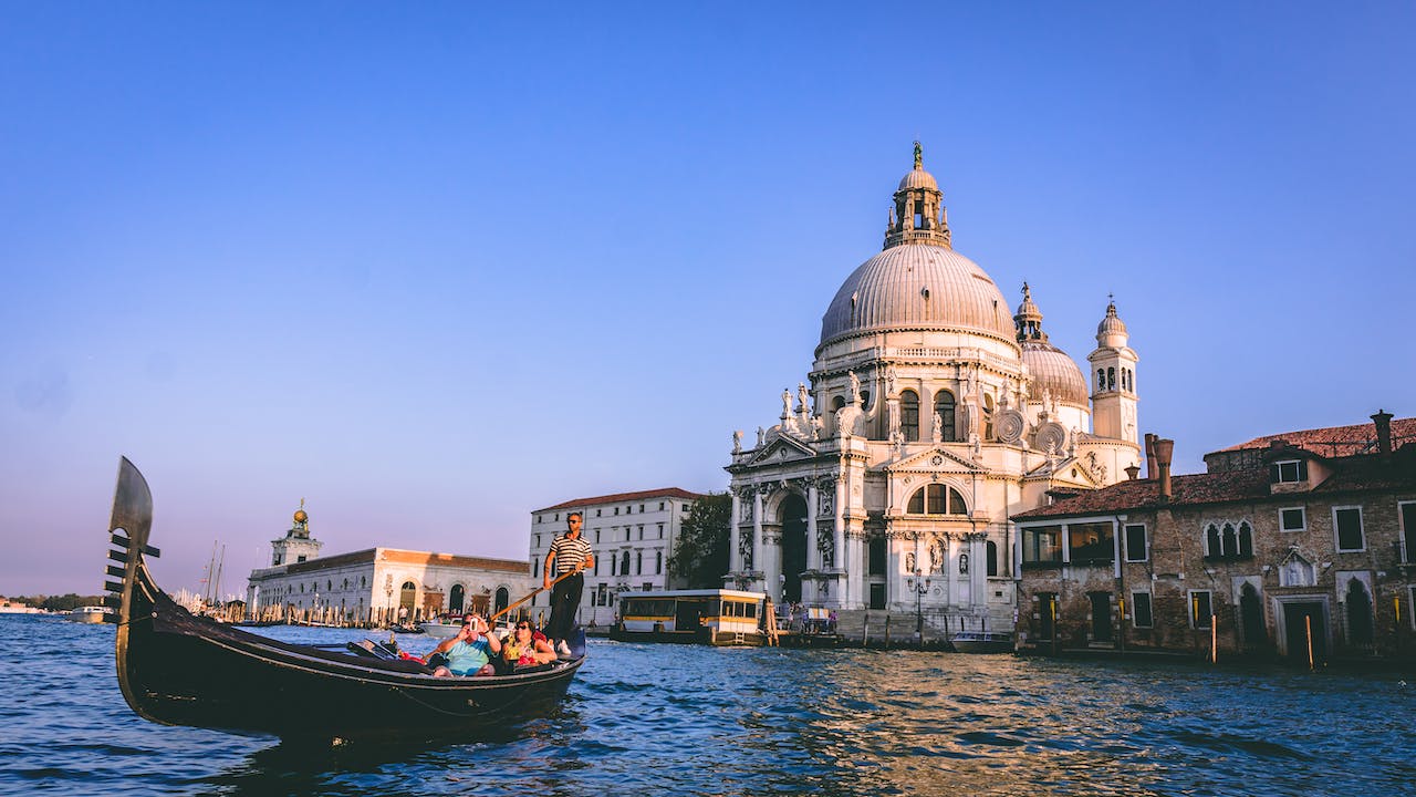 Check out these fun facts about Italy. Pictured: tourists on a boat exploring Italy.