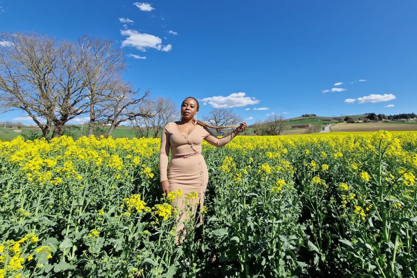 Faith Katunga standing in a field of flowers