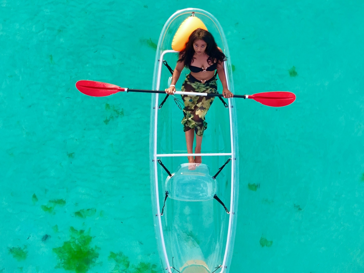 woman in clear glass boat in blue sea