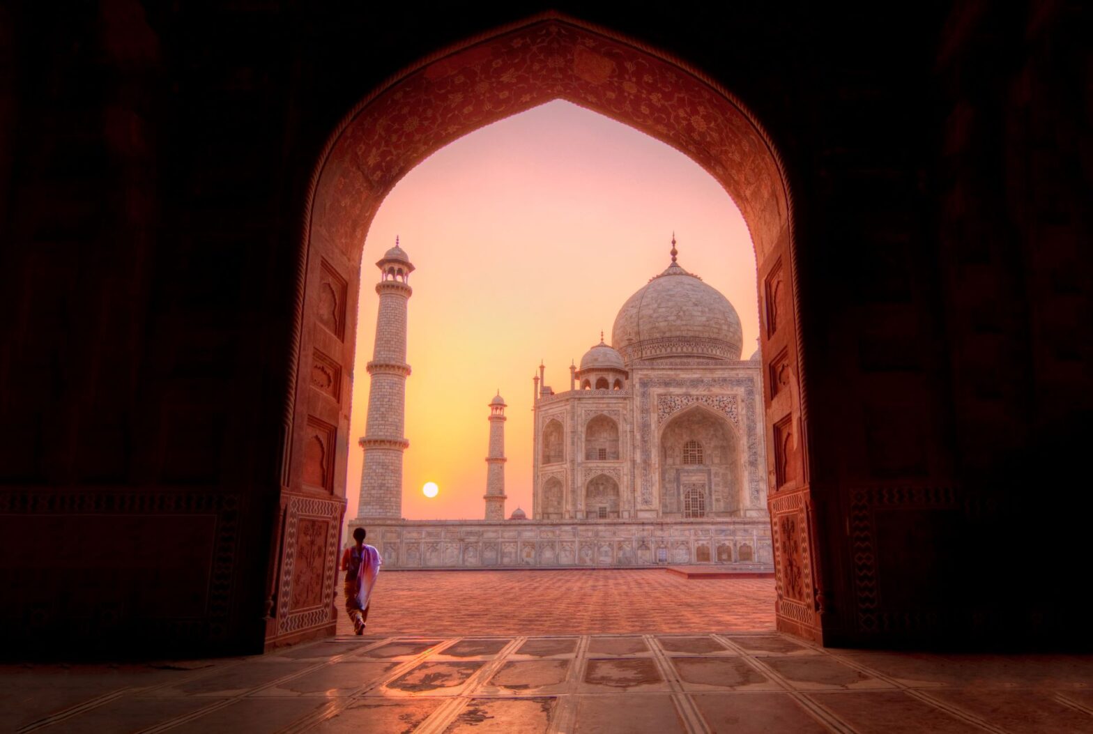 woman in traditional sari watching sunrise over Taj Mahal