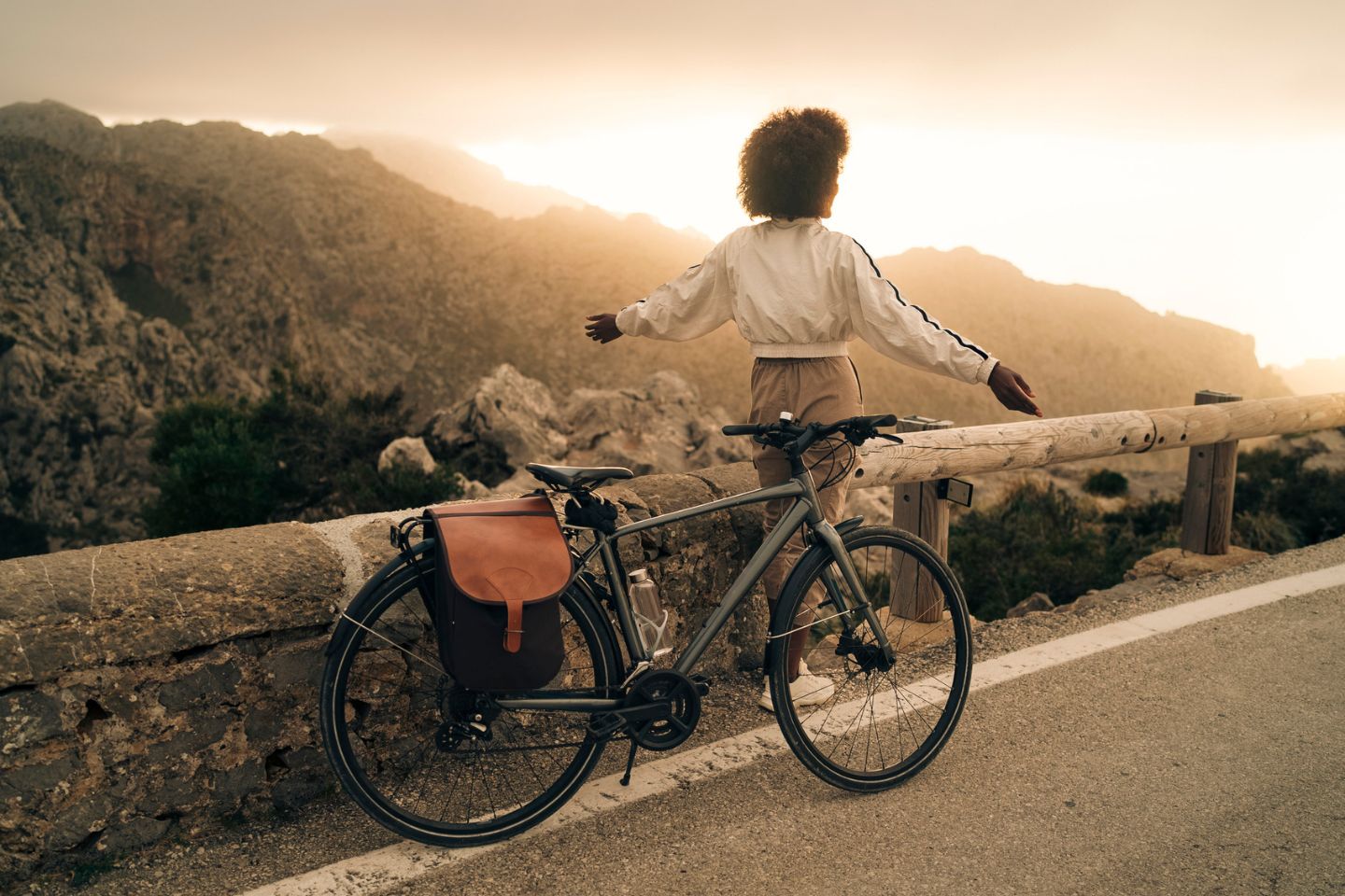 woman taking scenic break during bike road in mountains