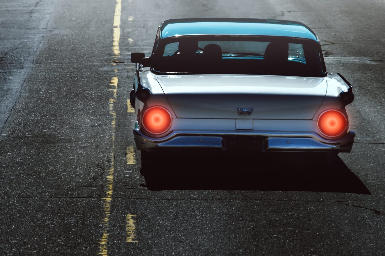 old car driving in the dark