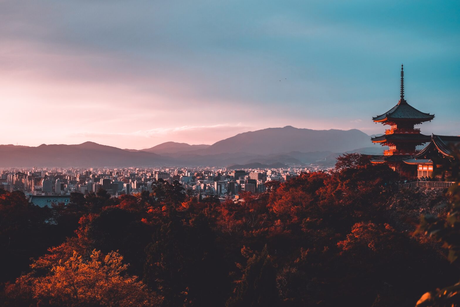 Kyoto, Japan is an underrated yet wonderful place to visit. It can be hard to navigate the dense city, but these hotels are the most comfortable and welcoming. pictured: a skyline view of Kyoto during sunset in the fall