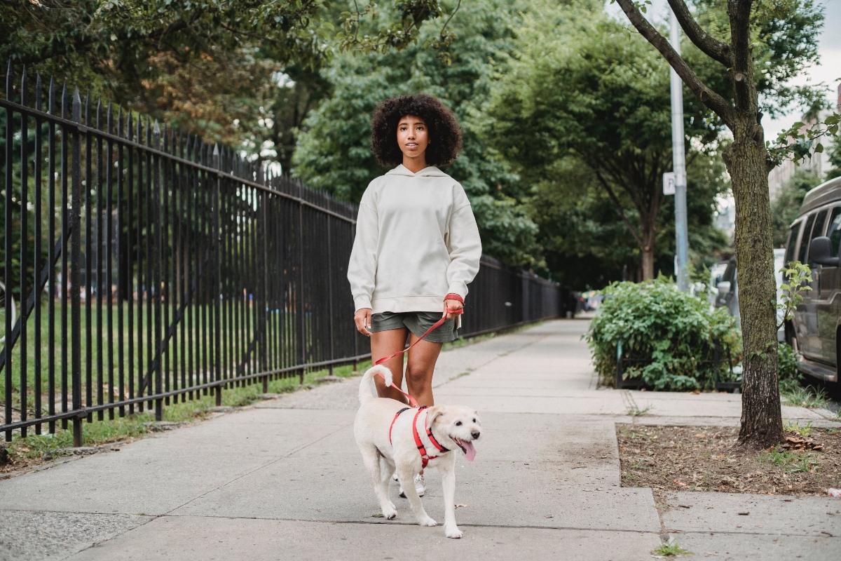 Black woman with dog on sidewalk