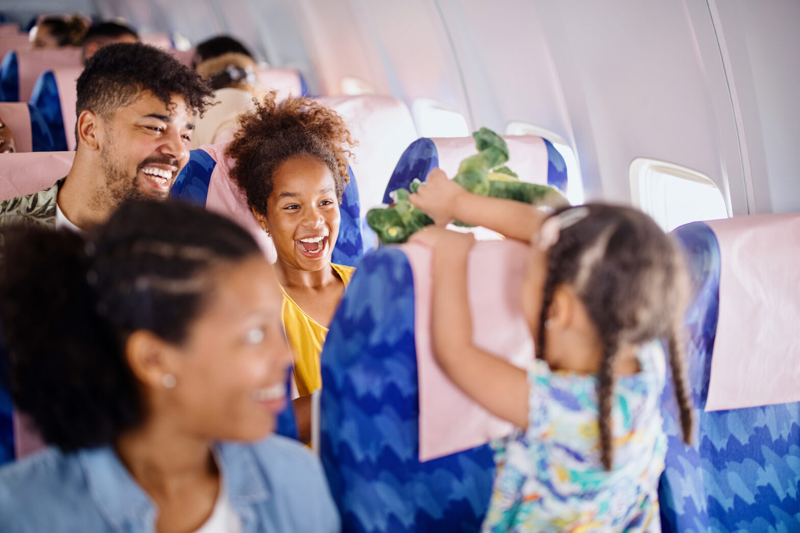 Sisters play with plush toys while traveling by plane