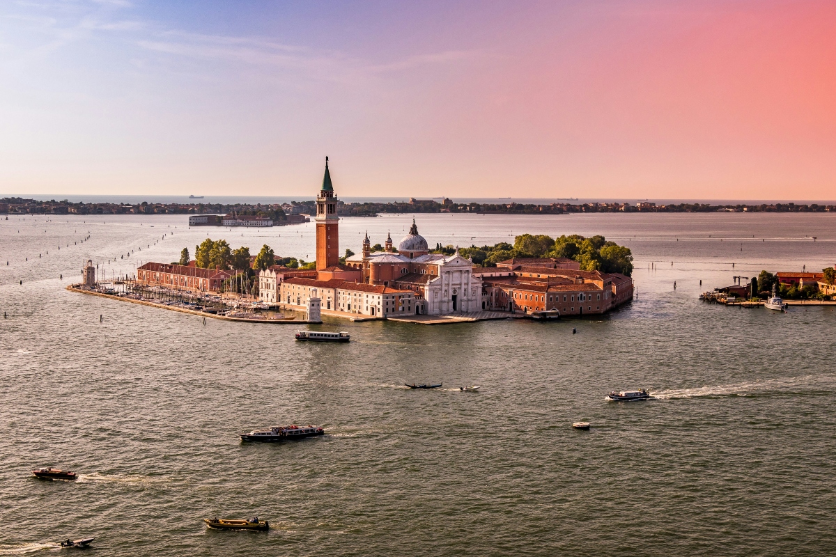 Aerial view of boats in water near Venice, Italy at sunset.