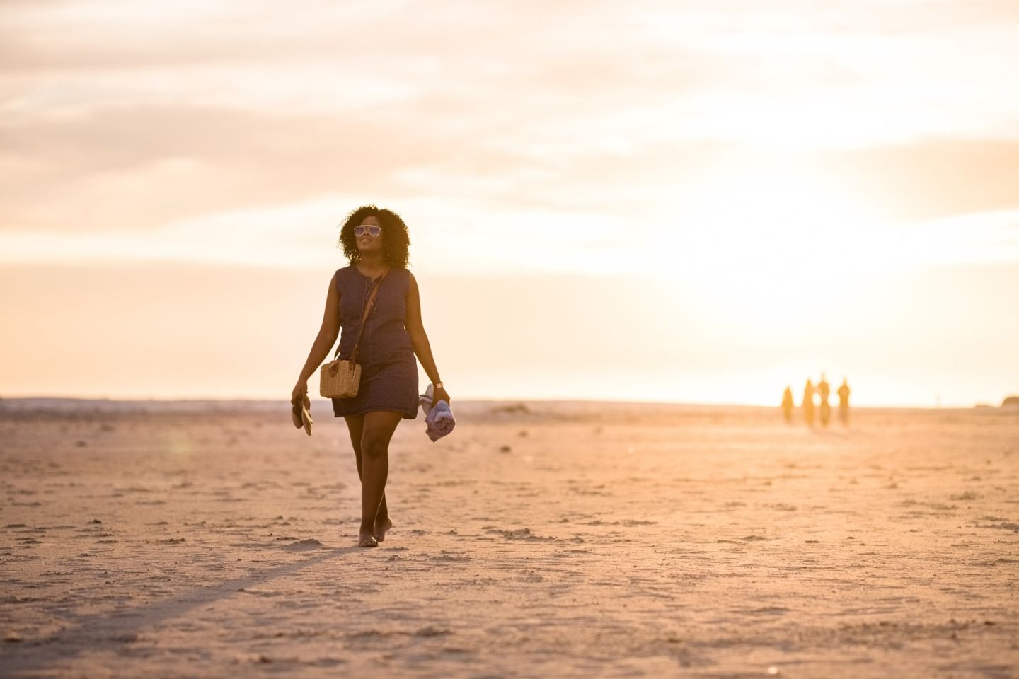 woman walking along the beach at sunset