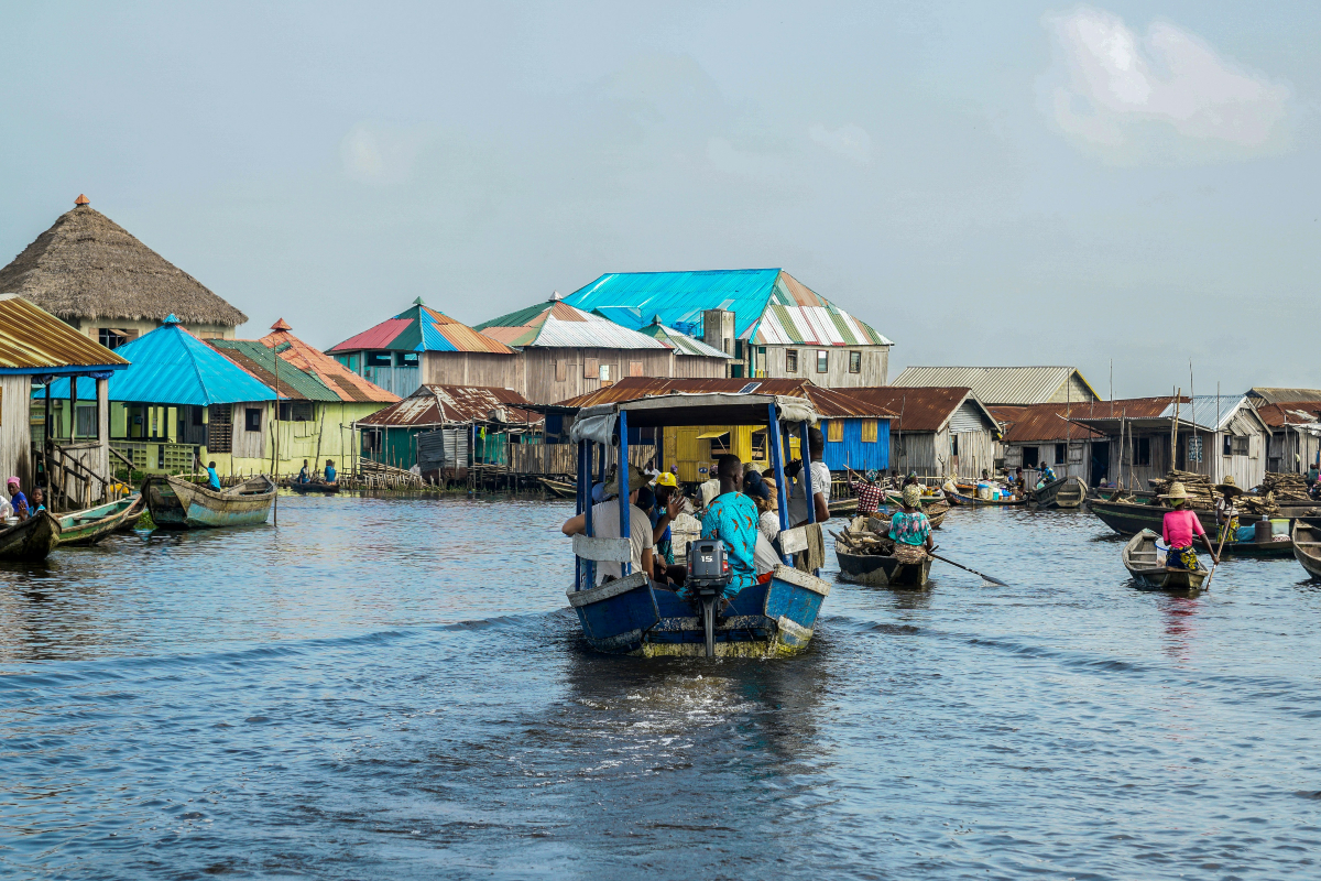 a group of people ride on boats with Tonlé Sap in the background