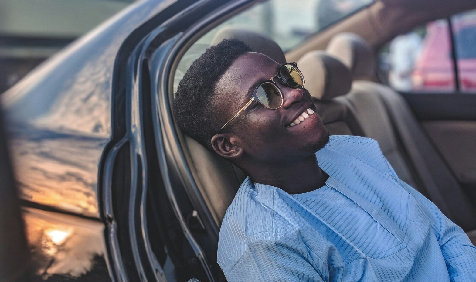 man smiling while sitting in car