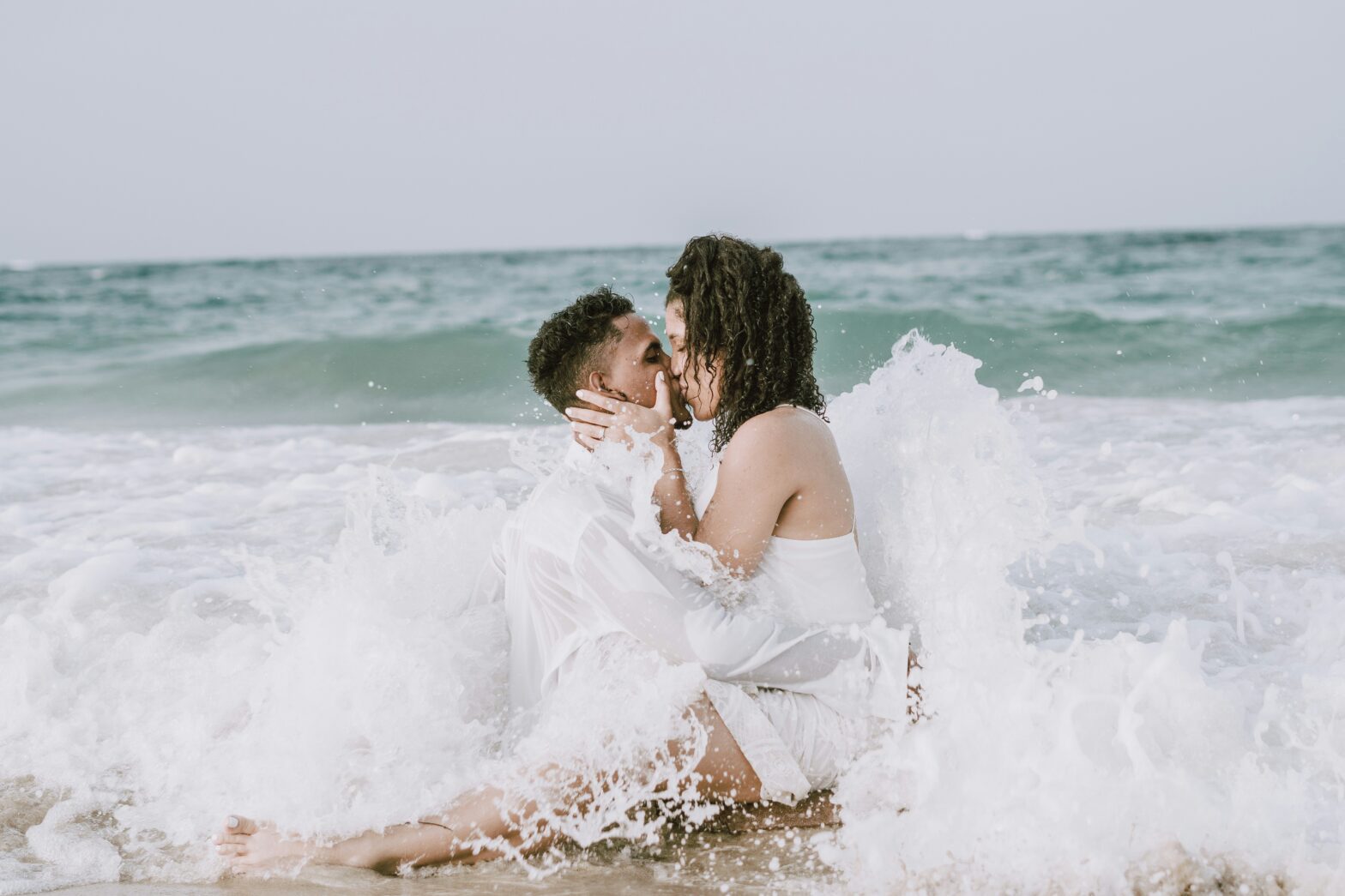 man and woman kissing on the beach