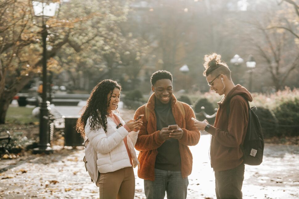 friends smiling using apps on phone 