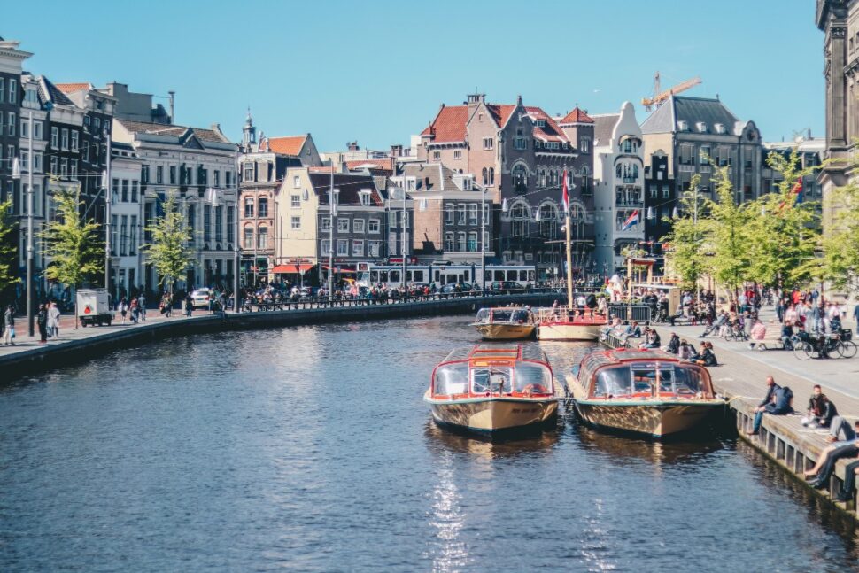 best places to visit in europe Pictured: boats on a waterway in Amsterdam, Netherlands