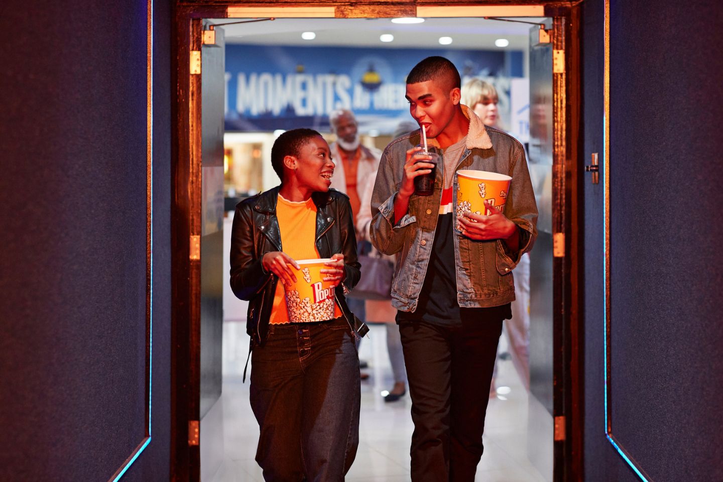 couple walking into movie theater with food and drinks