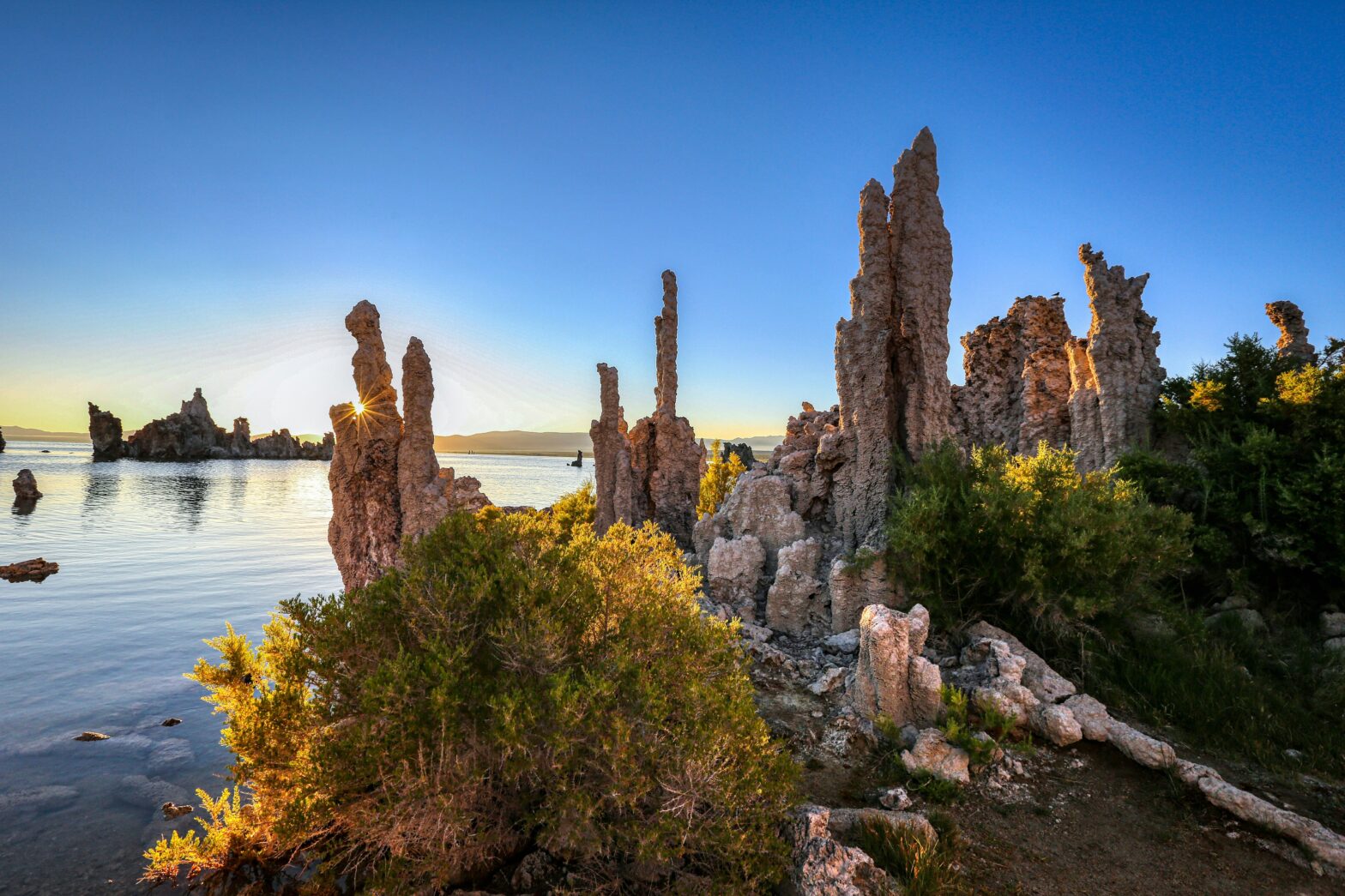 Check out these locations and where “High Plains Drifter” was filmed. Pictured: a rugged rock formation in front of the water and sunset