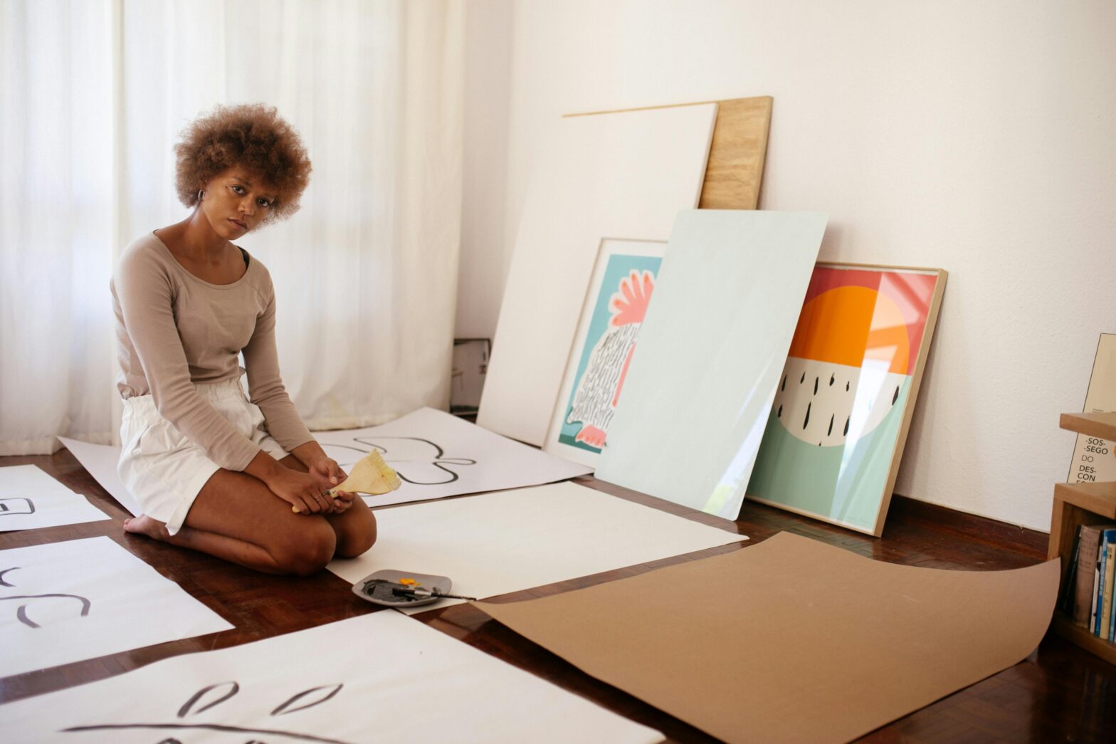 woman sitting in front of paintings