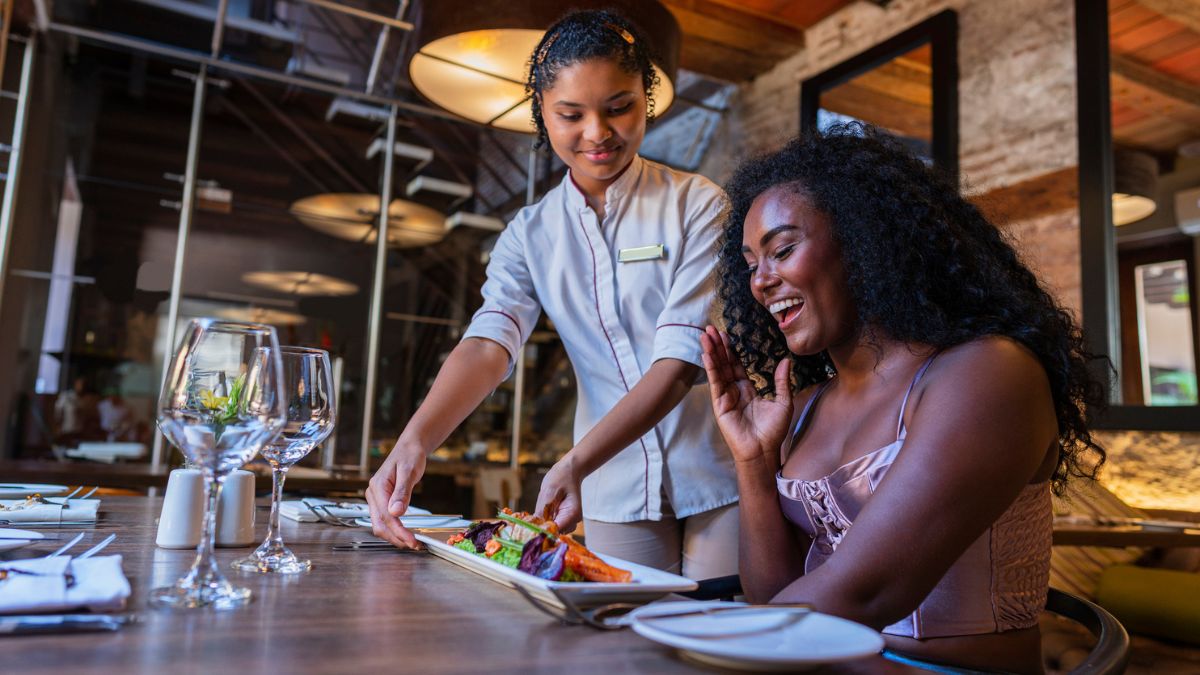 woman being served a meal at fine dining restaurant