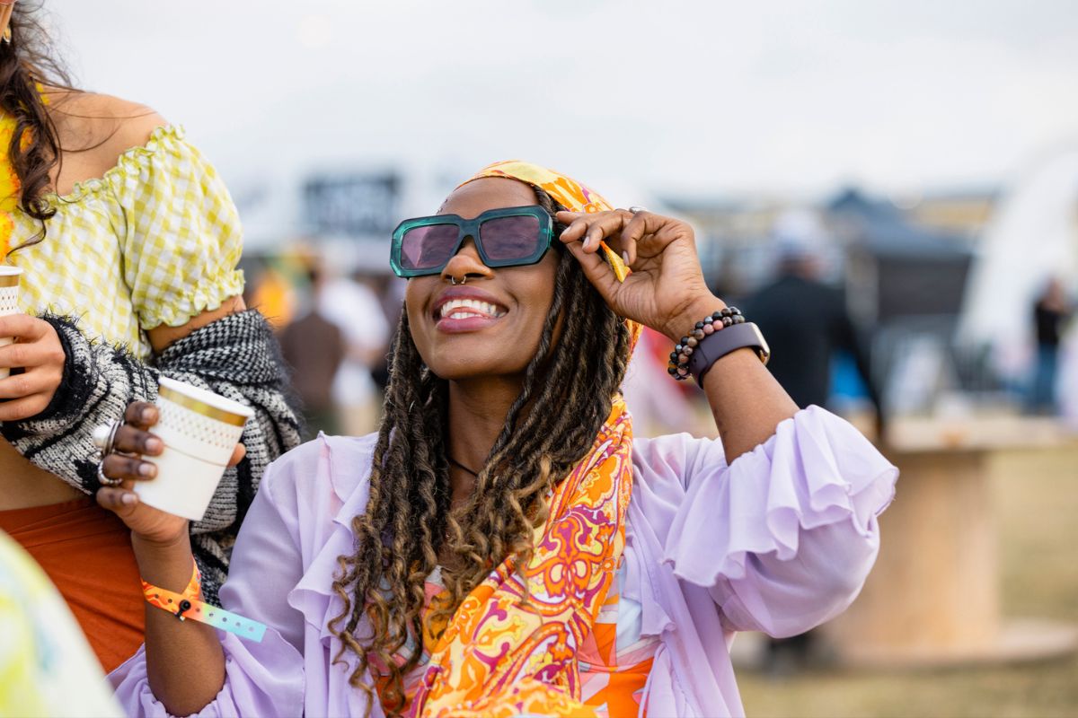 Black woman laughing with friends at a festival