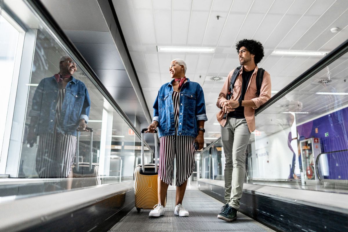 couple on walking escalator smiling at the airport