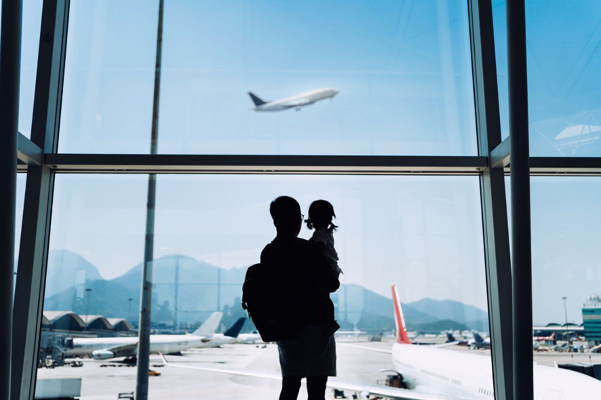 parent holding a baby while watching planes take off at airport putting babies to sleep in hotel closets