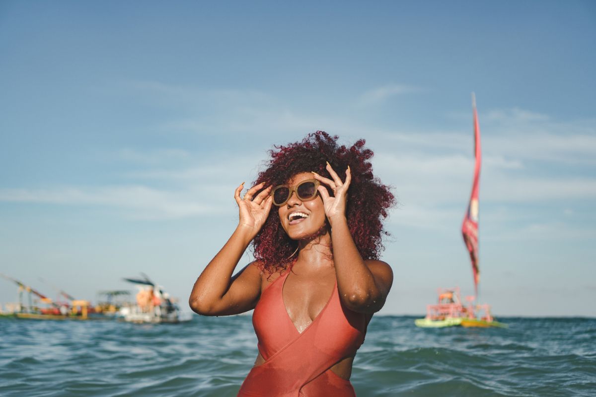 woman posing in sunglasses on the beach