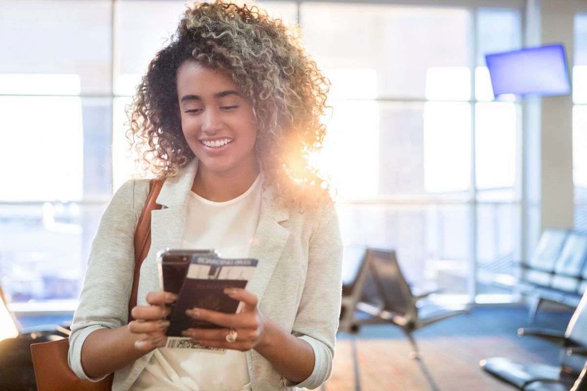 woman at airport terminal looking at phone