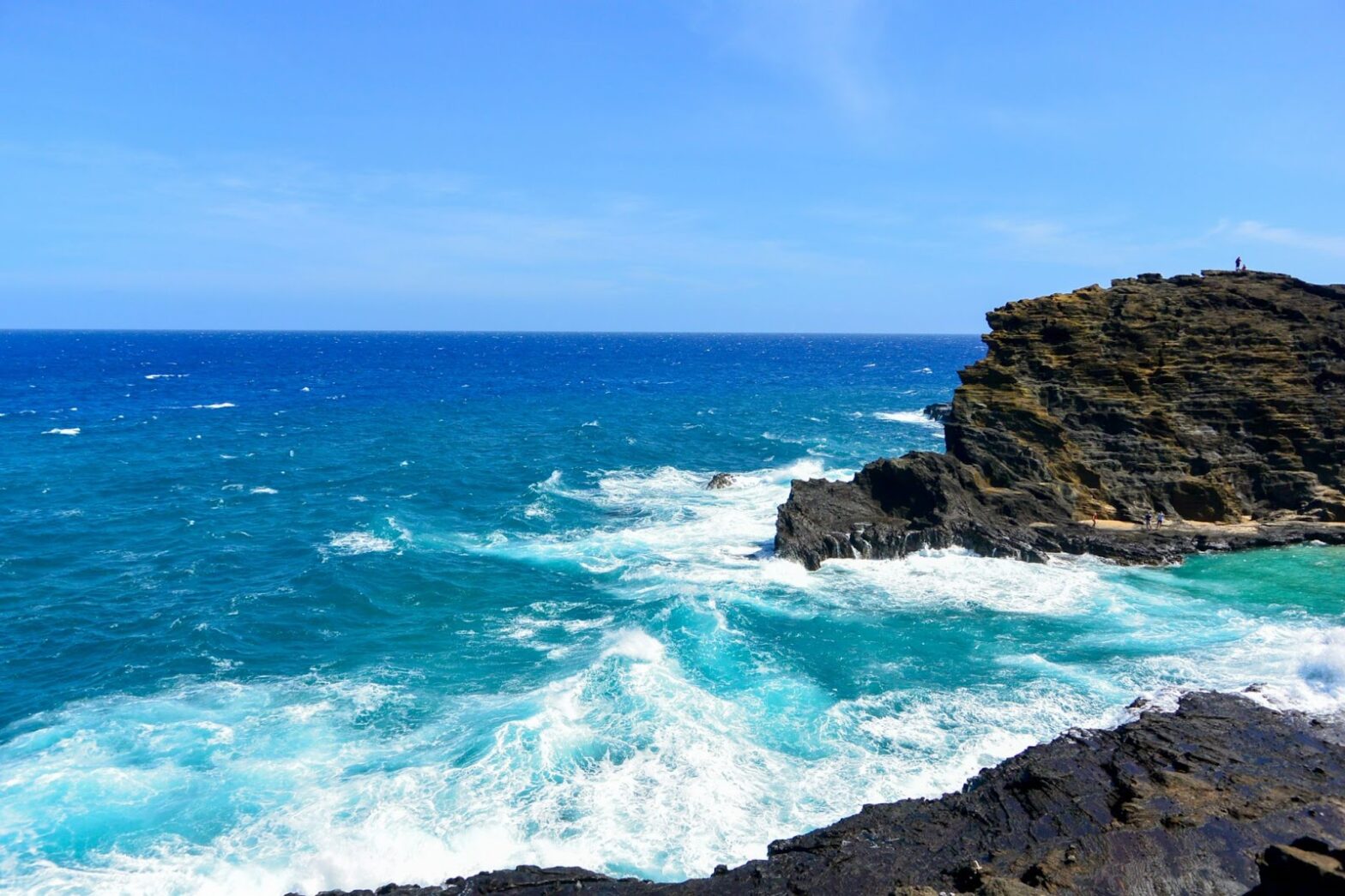 Check out the top rated beach with blue vibrant color. pictured: a beach with rocks and bright blue water