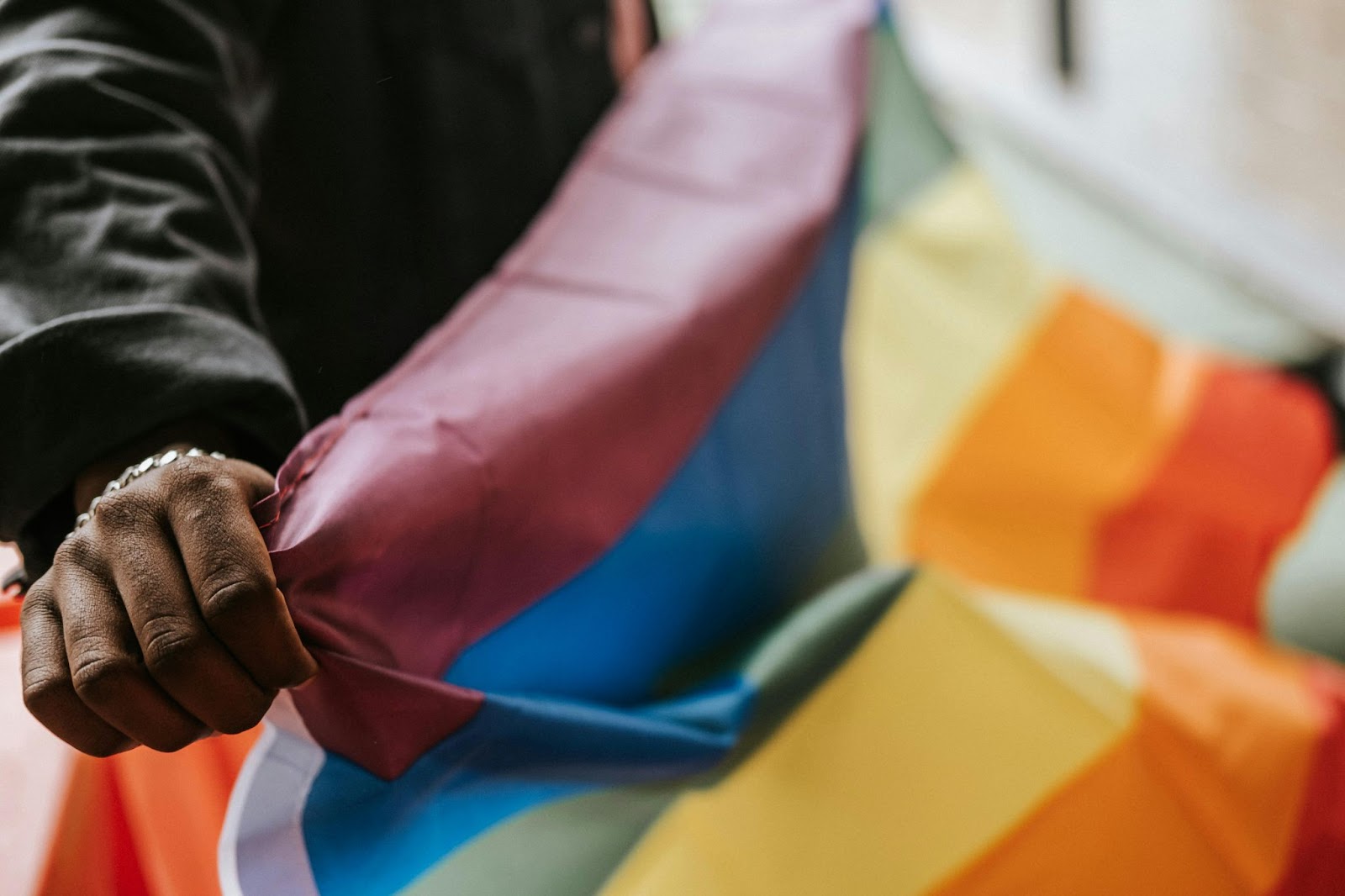 May is the best time to visit Puerto Vallarta due to Pride Month. 
pictured: a Black man holding a LGBTQIA+ flag 