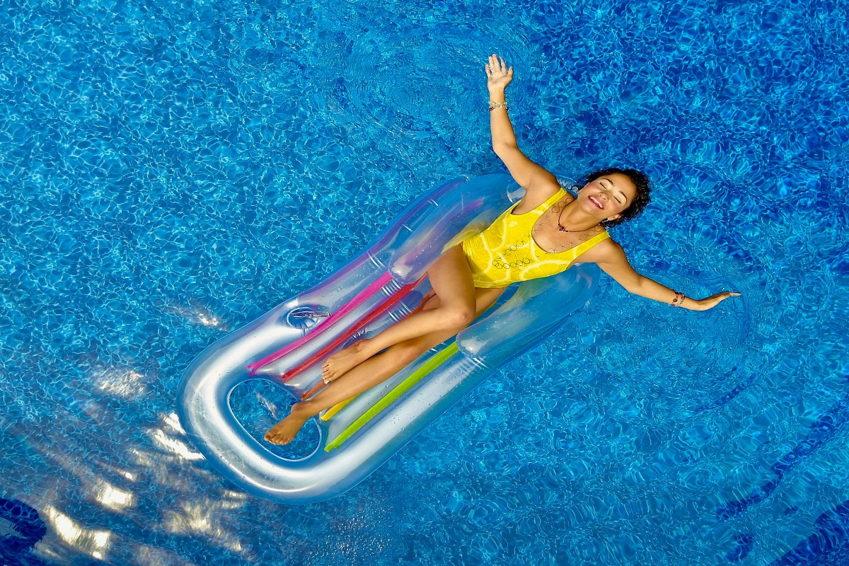 woman floats on an air mattress in summer