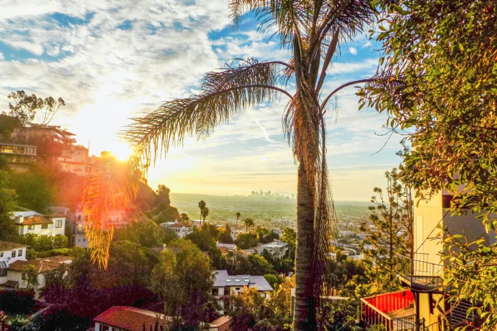 
a view of downtown Los Angeles' skyline from the West Hollywood Hills just after sunrise in