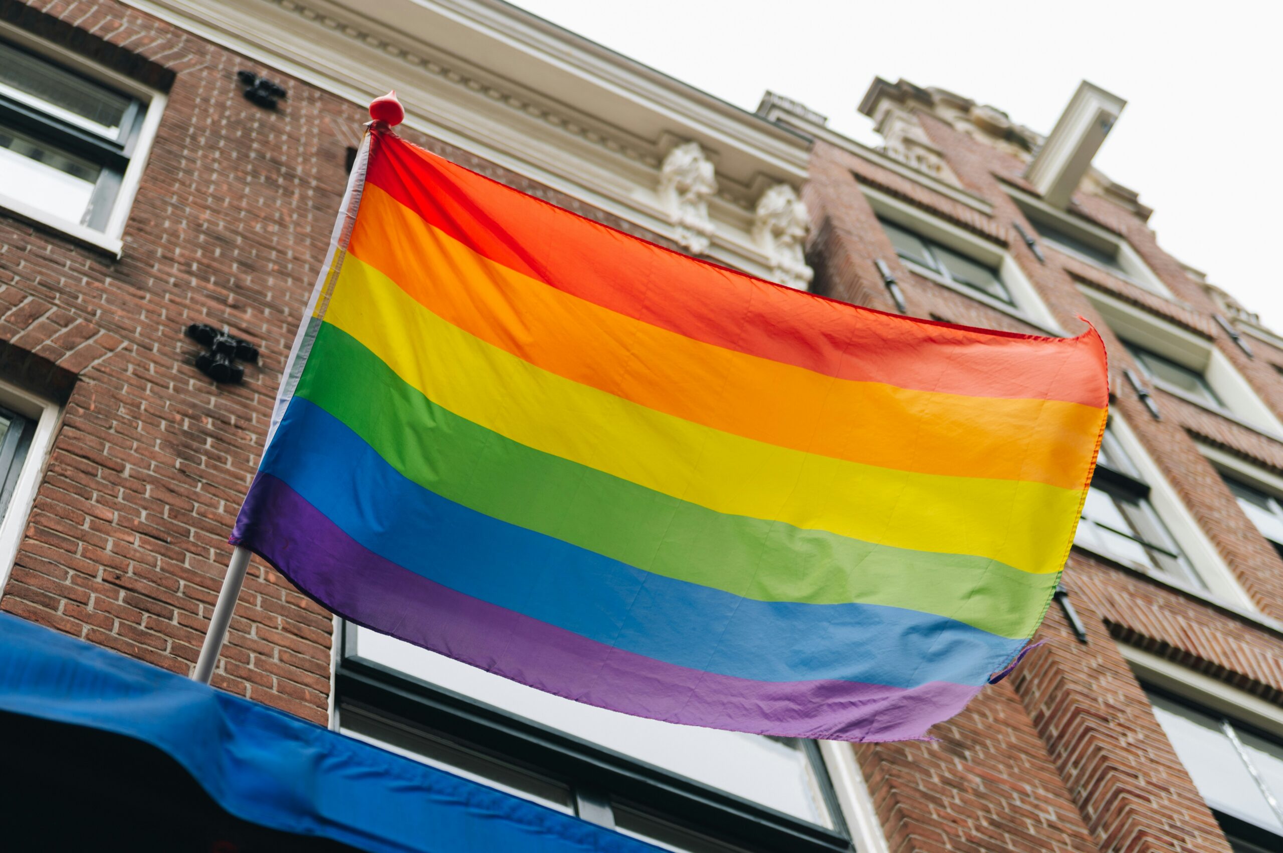 Here is what travelers should know about the upcoming Global Black Pride.
pictured: a pride flag on a city building 