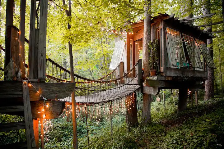 This secluded treehouse is near Atlanta and is one of the best off the grid Airbnbs.
Pictured: treehouse with lights in the woods