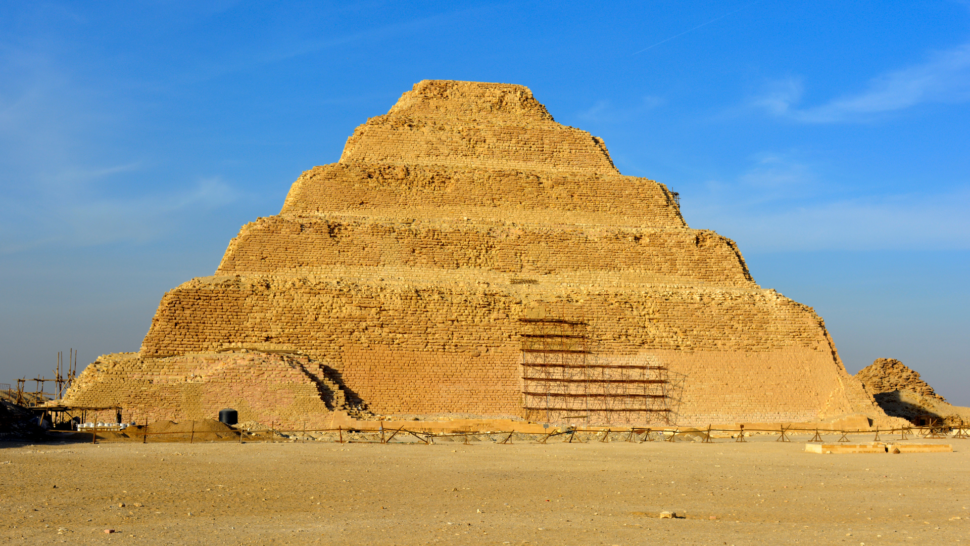 The Step Pyramid of Djoser, the first pyramid ever built, against a blue sky