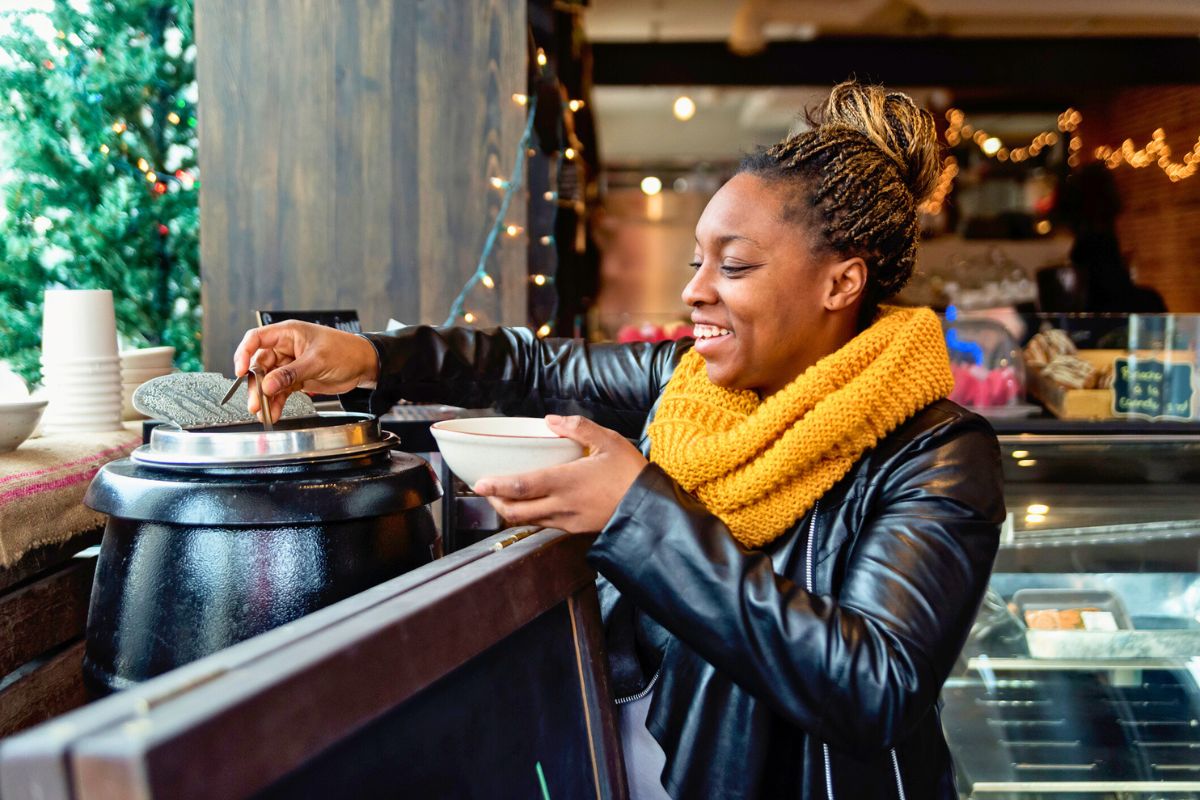 woman making bowl of soup at a restaurant