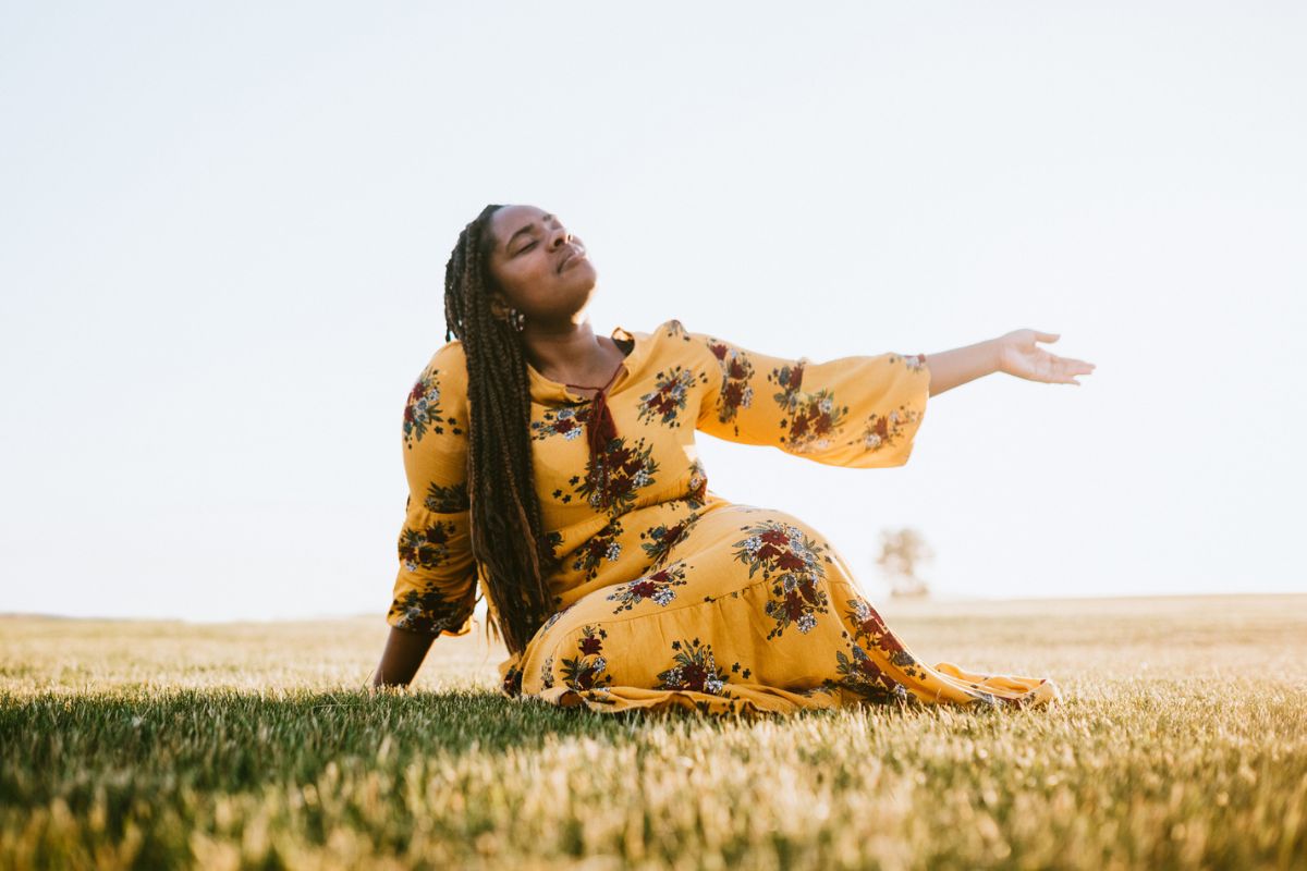 woman wearing bright sun dress in a field