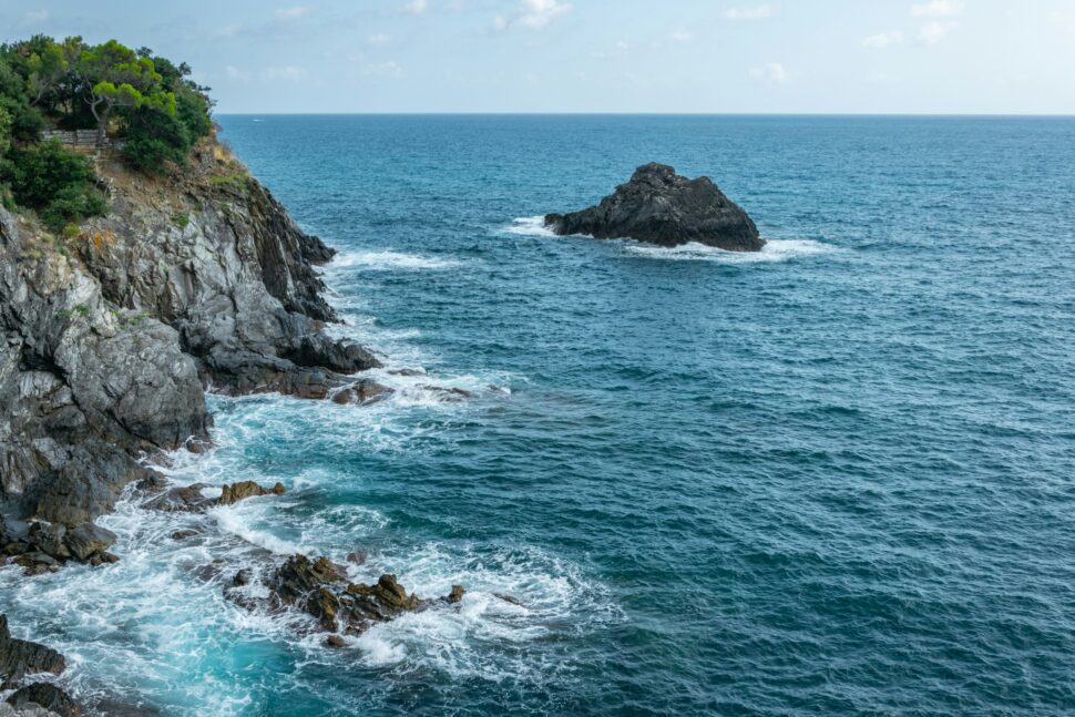 Blue waves crashing into rocks in Italy 