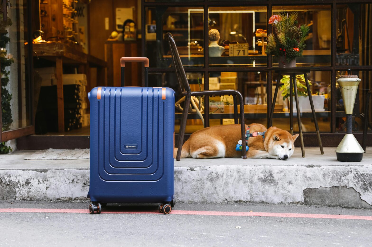 Blue suitcase place outside of a storefront