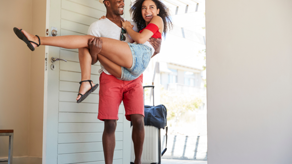 Man carrying in girlfriend by doorway