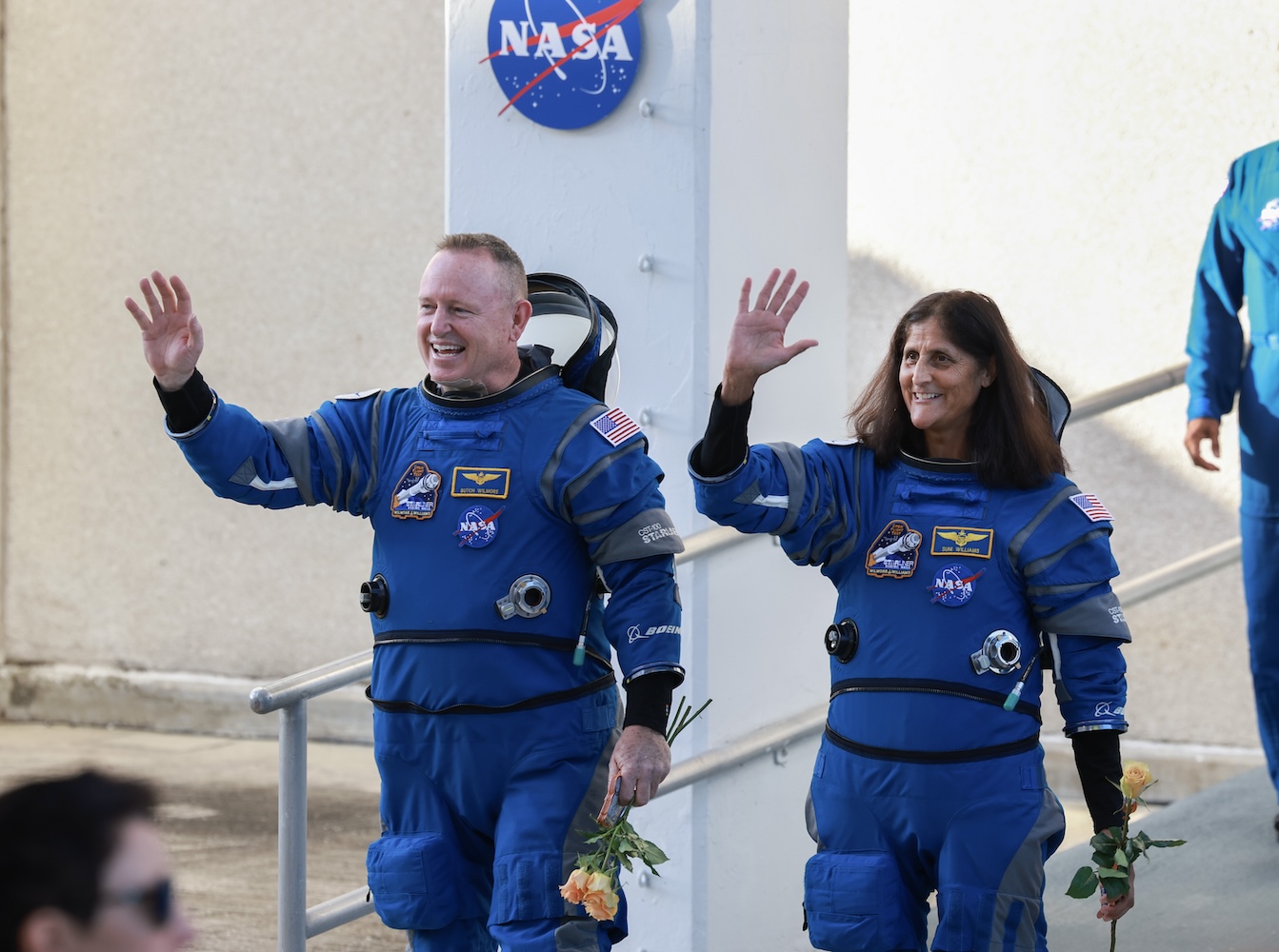 NASA’s Boeing Crew Flight Test Commander Butch Wilmore (L) and Pilot Suni Williams walk out of the Operations and Checkout Building