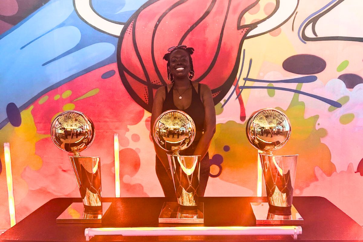 Osby standing behind the Miami Heat championship trophies.