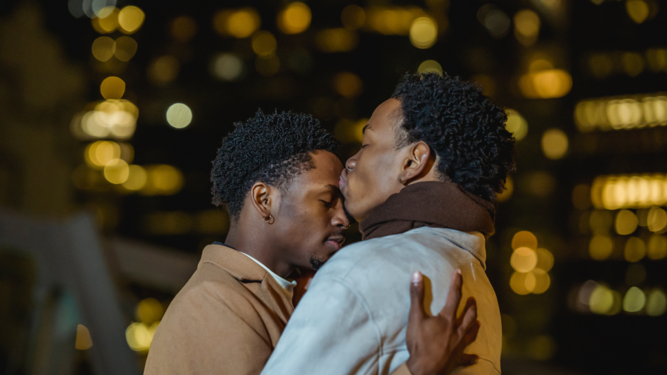 Black couple embracing in a hug and kiss on forehead 