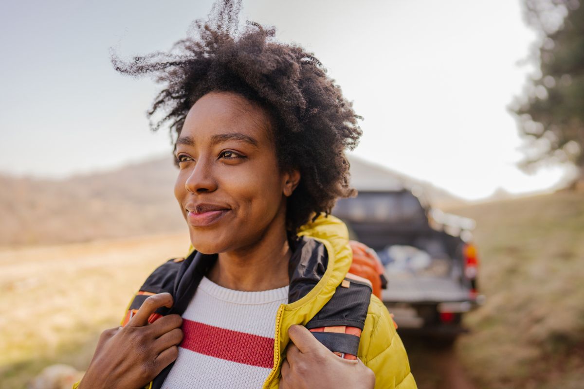 woman carrying a backpack while camping