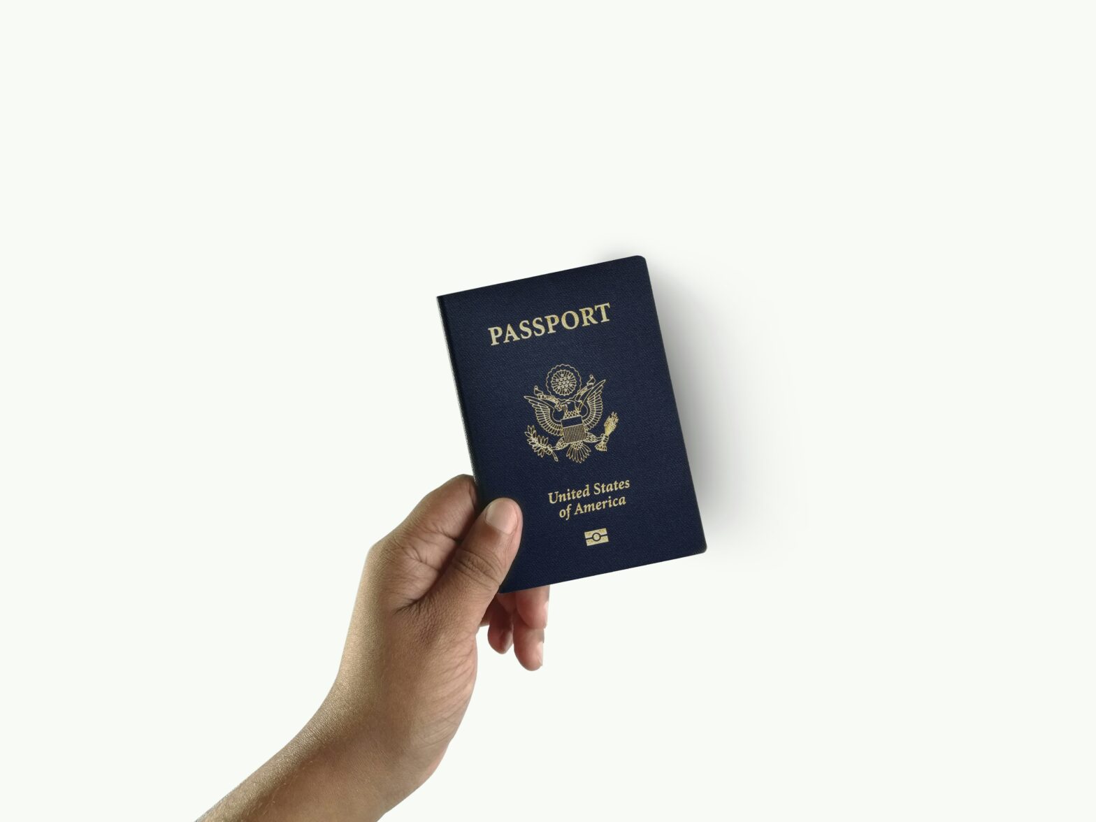 A hand holding a passport book.