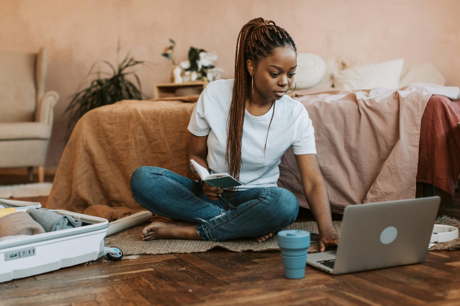 woman sitting on floor scrolling on laptop