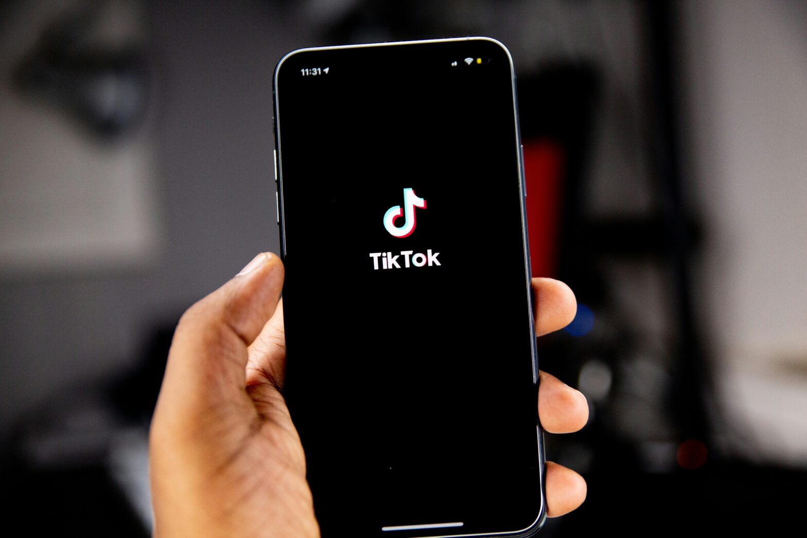 Man holding phone with TikTok on it.