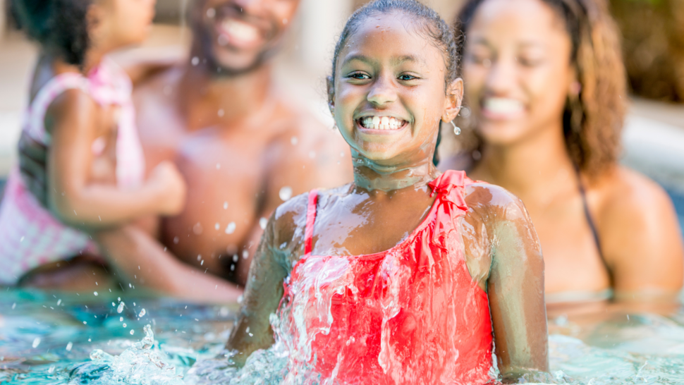 African American family enjoying playing in the pool